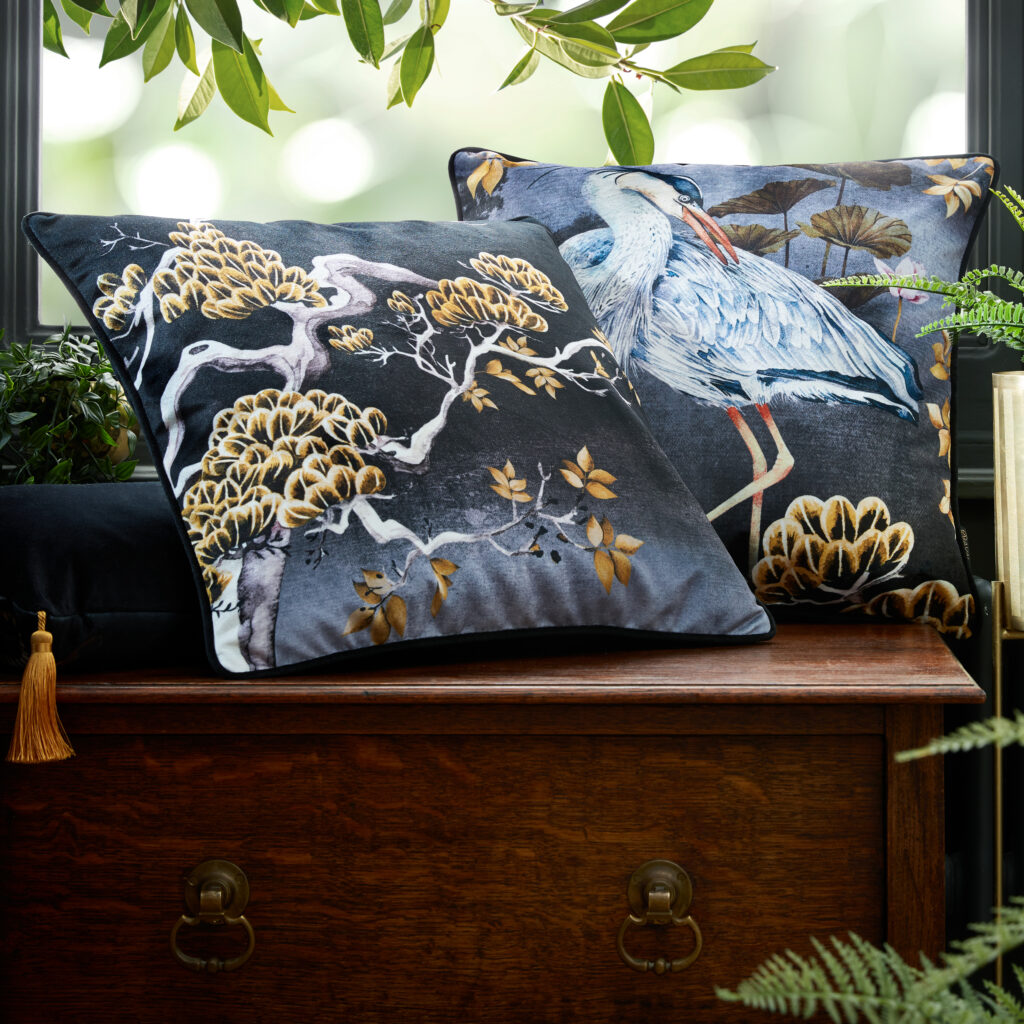 Midnight orient and midnight orient tree cushions sat on a wooden bench by a window
