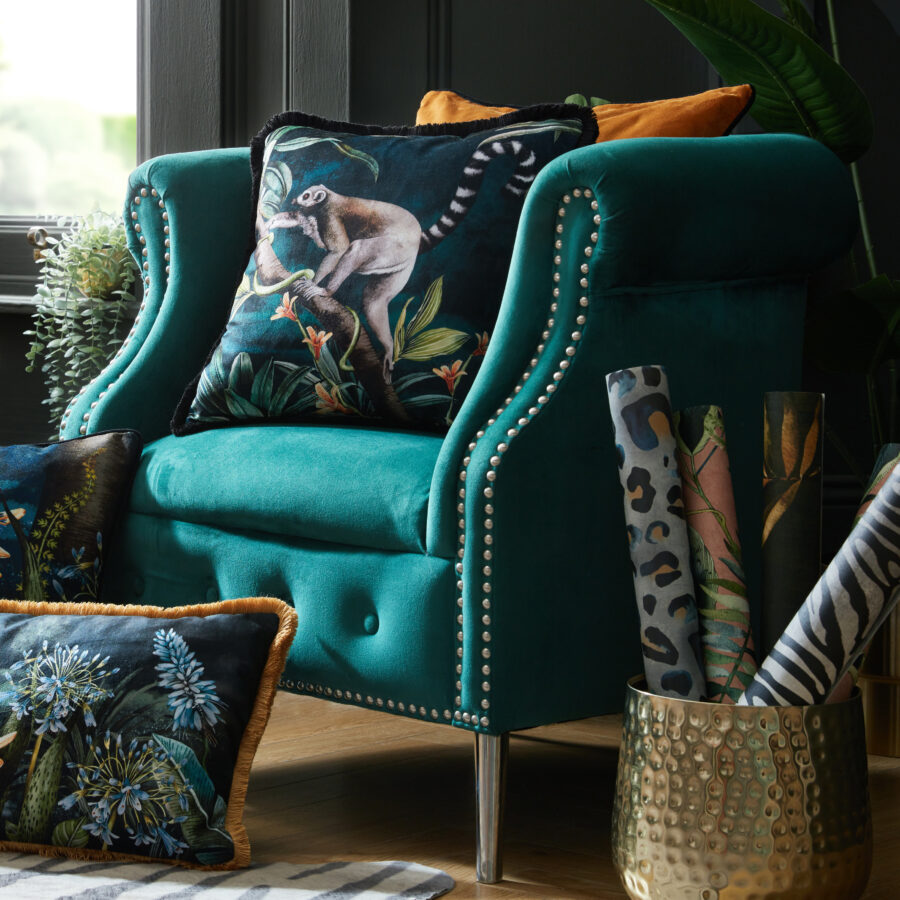 Lemur cushion with black velvet fringe on a teal chair in sitting room